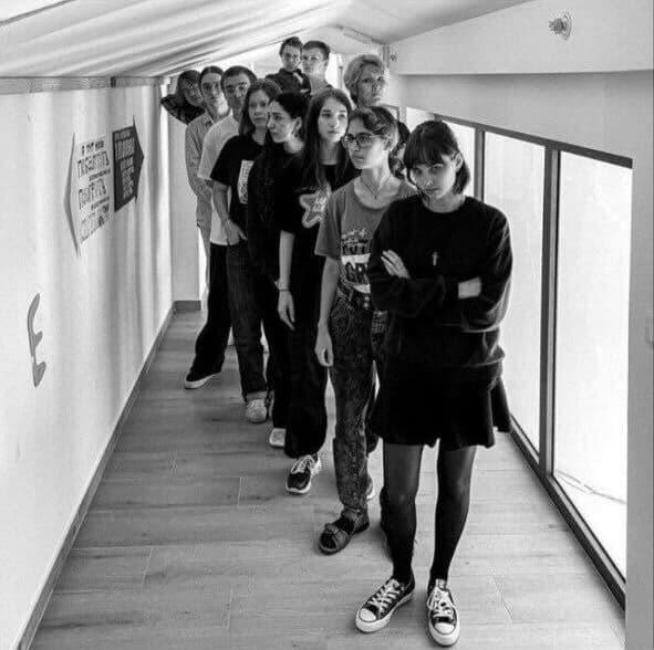 Group of young people standing in a hallway